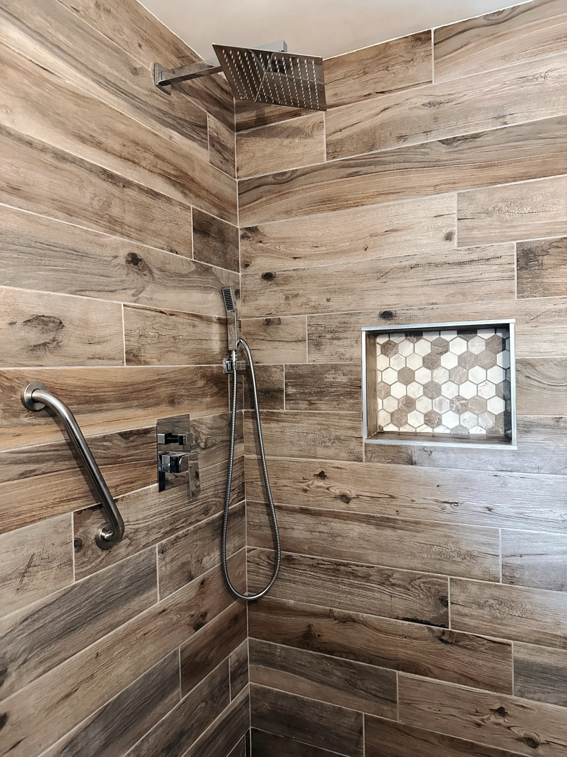Shower with wood-look plank tile walls installed in an El Paso, TX bathroom