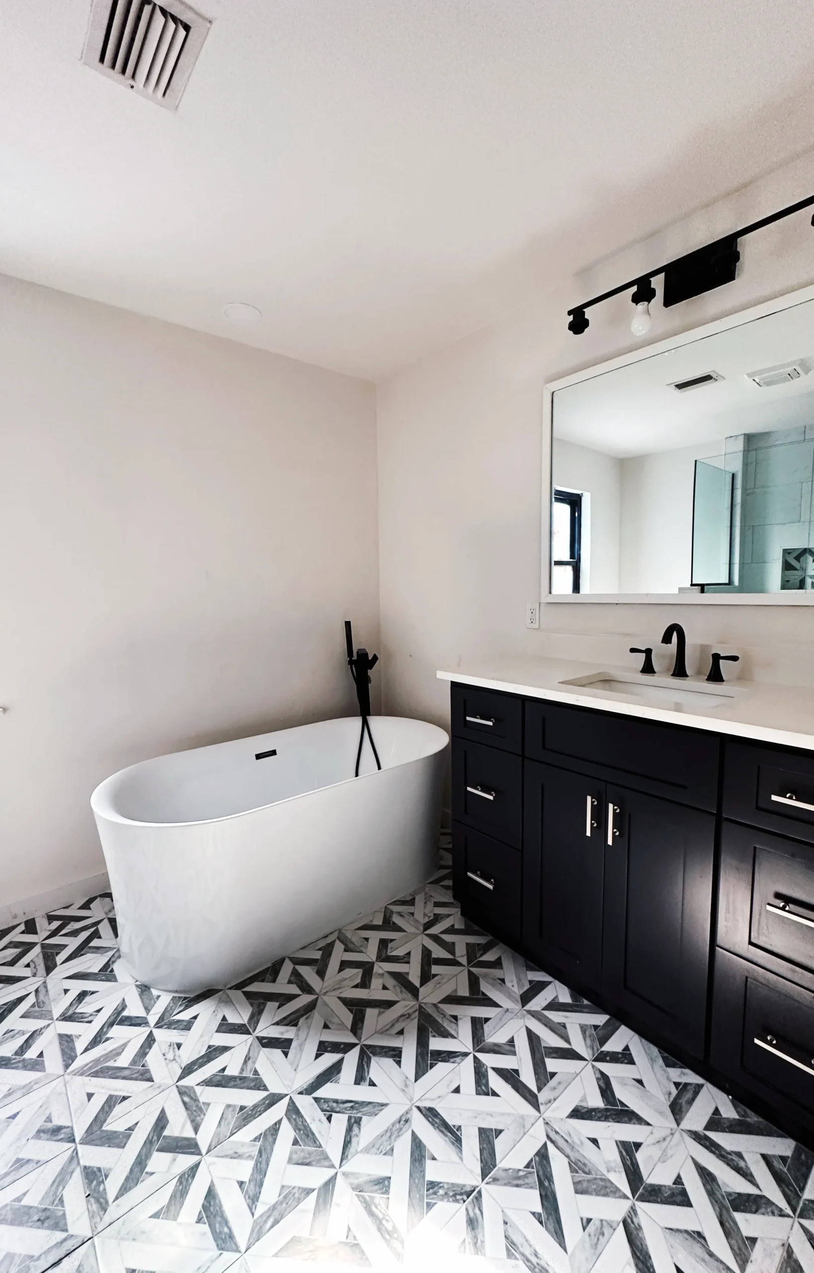 Bathroom with freestanding tub and marble-look tile installed in an El Paso, TX home