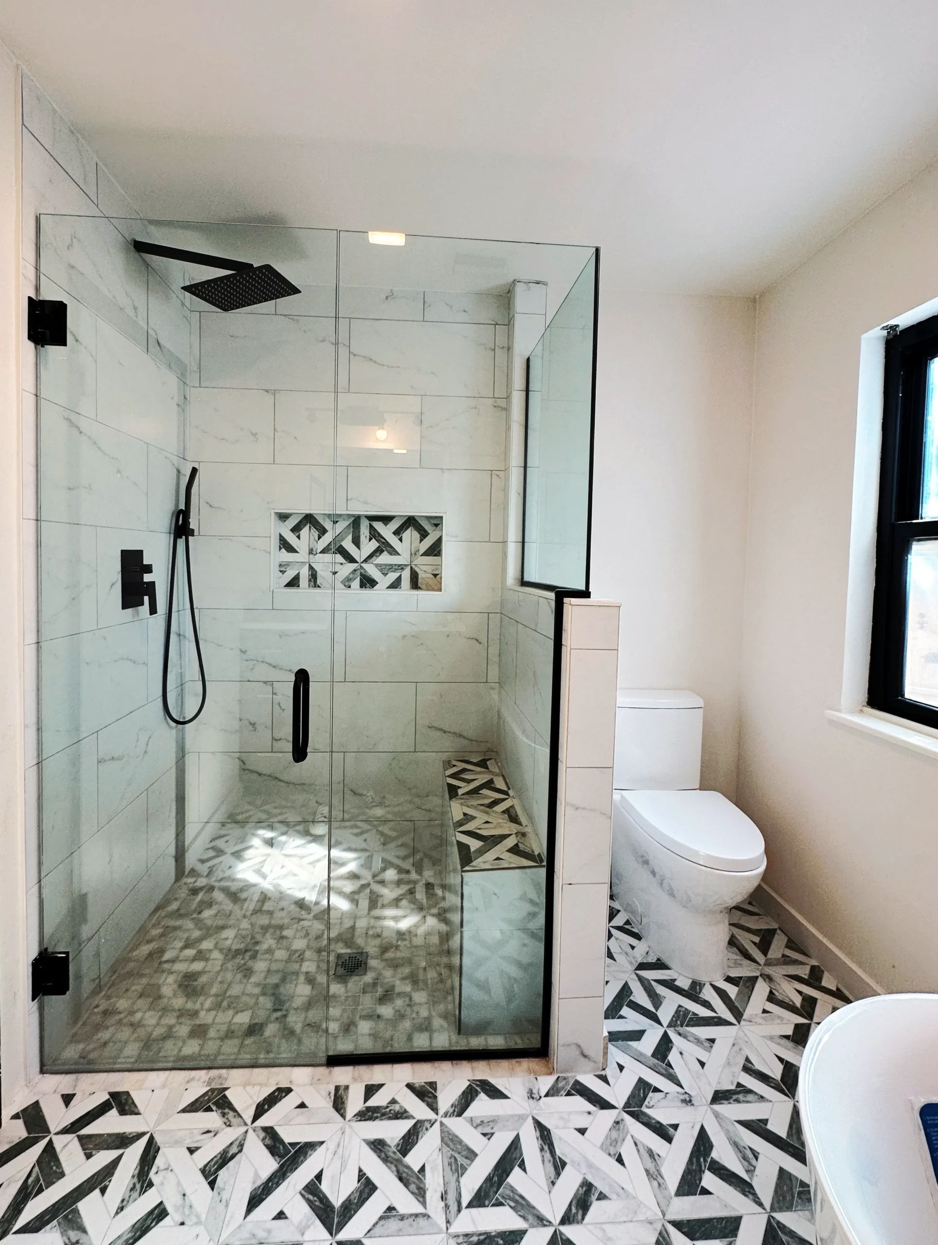 Tiled shower with mosaic floor installed in an El Paso, TX bathroom